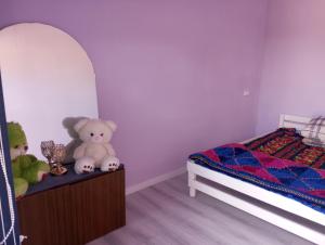 a bedroom with a bed and stuffed animals on a dresser at Asian Guest House in Bishkek