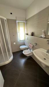 ein Badezimmer mit einem Waschbecken, einem WC und einem Waschbecken in der Unterkunft B&B DIVINO in Calceranica al Lago
