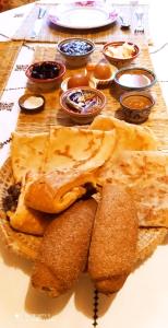 a plate of food with bread and some dips at maison d'hôtes Le petit jardin Marrakech in Marrakech
