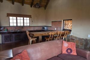 eine Küche mit einem Sofa, einem Tisch und einer Theke in der Unterkunft Top Lodge in Bonjaneni