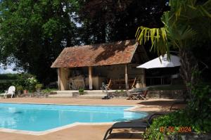 a house with a swimming pool in front of it at Maison de campagne in Sancergues