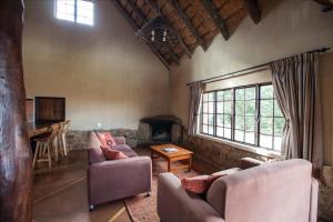 ein Wohnzimmer mit 2 Sofas und einem Kamin in der Unterkunft Top Lodge in Bonjaneni