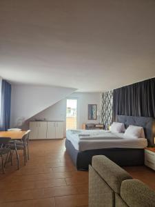 1 dormitorio con 1 cama, mesa y sillas en Penzion Relax Martina, en České Budějovice