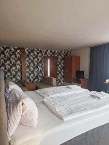 ein Schlafzimmer mit einem großen weißen Bett in einem Zimmer in der Unterkunft Penzion Relax Martina in Budweis