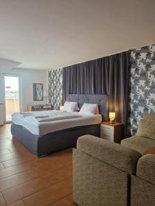 1 Schlafzimmer mit einem großen Bett und 2 Stühlen in der Unterkunft Penzion Relax Martina in Budweis