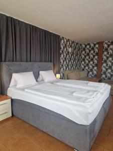 uma grande cama branca num quarto com cortinas em Penzion Relax Martina em České Budějovice