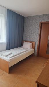 Bett in einem Zimmer mit einem blauen Vorhang in der Unterkunft Penzion Relax Martina in Budweis