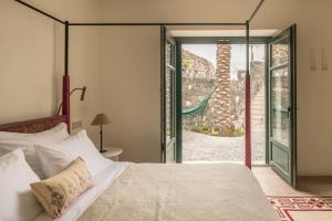 a bedroom with a bed and a sliding glass door at Patina Vivera Estate Santorini in Pyrgos