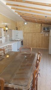 a dining room with a large table and a kitchen at Paisible Chalet 5 personnes maxi en option 8 pers SPA in Largentière