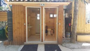 a wooden building with a toilet inside of it at Paisible Chalet 5 personnes maxi en option 8 pers SPA in Largentière