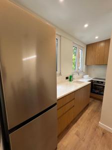 a kitchen with a stainless steel refrigerator and wooden cabinets at Sophie Apartment in Tirana +8 photos