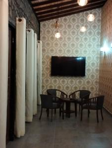 comedor con mesa, sillas y TV en Jacks Lounge and Hotel, en Kandy