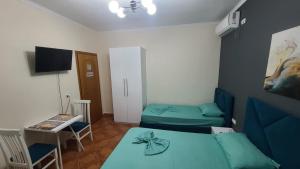 都拉斯Guest House Tian & Hojz的有两张床、一张桌子和一台电视的房间