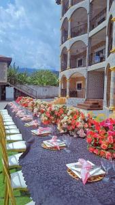 - une grande table avec des chaises, des assiettes et des fleurs dans l'établissement ROCK CASTLE FURNISHED APARTMENTS, à Limbe