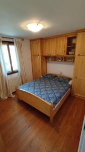 a bedroom with a bed in a room with wooden cabinets at Kuća za odmor Giulitta in Porat
