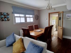 ein Wohnzimmer mit einem Tisch und einem Sofa in der Unterkunft 3 Bedroom Cottage in Sunninghill, Ascot in Sunninghill