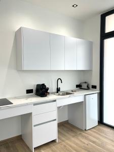 a white kitchen with white cabinets and a sink at Avakianni Boutique in Valencia