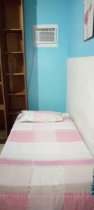 a small bedroom with a bed with a blue wall at Candida in Caracas