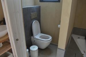 La salle de bains est pourvue de toilettes blanches et d'un lavabo. dans l'établissement Gate Away B&B Units - המקום באל רום, à El-Rom