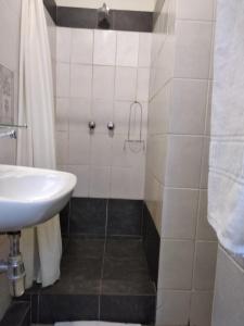 uma casa de banho com um lavatório e um chuveiro em Brackendene Lodge em Gaborone
