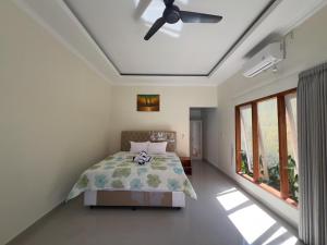 a bedroom with a bed and a ceiling fan at Anugerah Villa 3 in Amed +24 photos