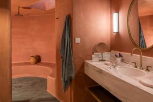 a bathroom with a sink and a tub at Patina Vivera Estate Santorini in Pirgos