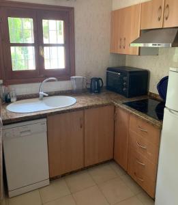 a kitchen with a sink and a microwave at Charming 3-storey house at residential golf resort in Muntanya la Sella