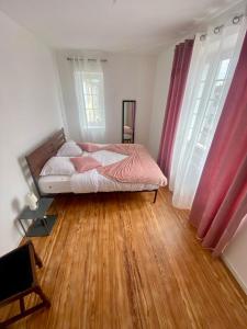 Schlafzimmer mit einem Bett und Holzboden in der Unterkunft Maison des Vignes in Tabanac