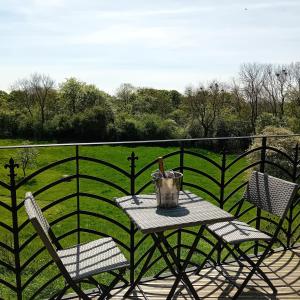 een tafel en stoelen op een balkon met een hek bij Castle Lodge in Sheriff Hutton