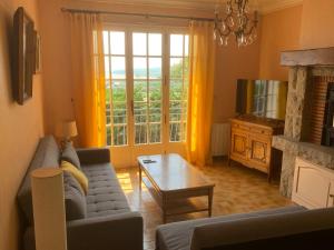a living room with a couch and a tv at Maison vue mer baie de Saint Brieuc in Plérin
