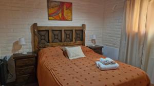 a bedroom with a orange bed with towels on it at Estacion Potrero Cabañas y Habitaciones in Potrero de los Funes +106 photos