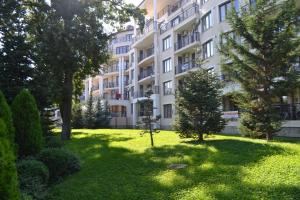 a large apartment building with trees in the yard at Sea View Rental Iglika Apartments in Golden Sands