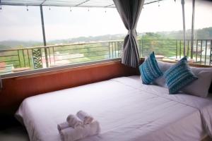 1 dormitorio con 1 cama con toallas en Homestay Măng Đen - ALamer en Kon Von Kla