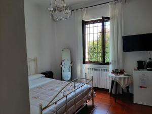 a bedroom with a bed and a window and a mirror at Villa Marco Aurelio in Cisano sul Neva