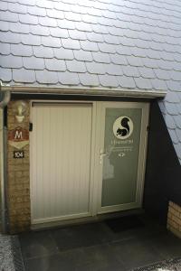 uma porta de garagem com um sinal em cima em L'Écureuil - Terrasses de Malmedy em Malmedy