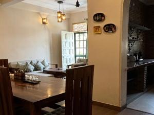 a dining room and living room with a table at 15 Verandah in Dehradun
