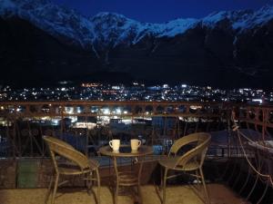 a table and chairs on a balcony at night at Belas guesthouse in Stepantsminda