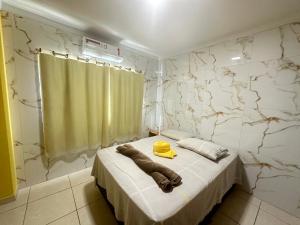 um quarto com uma cama com um chapéu amarelo em AP+preço popular+ar condicionado+internet 300mb em Goiânia