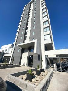 a large tall building with a fountain in front of it at Departamento con estacionamiento in Concepción