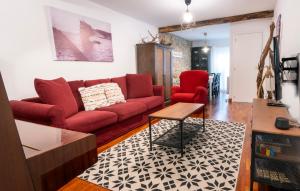 ein Wohnzimmer mit einem roten Sofa und roten Stühlen in der Unterkunft Taosa - ONGI ETORRI in Zumaia