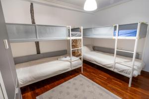2 Etagenbetten in einem Zimmer mit Holzböden in der Unterkunft Taosa - ONGI ETORRI in Zumaia