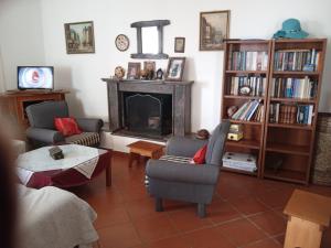 a living room with a fireplace with chairs and a table at Villa Tsiggos in Kanallákion