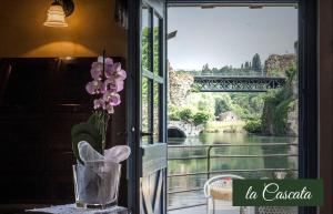 a window with a view of a river and a bridge at Il Borghetto Vacanze nei Mulini in Valeggio sul Mincio