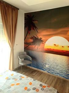 Un dormitorio con un cuadro del océano y una silla. en Apartment AS, en Ulcinj