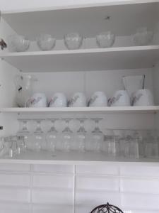uma prateleira cheia de copos e vasos no frigorífico em La SULINA em Sulina
