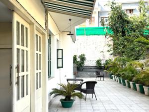 a courtyard with a table and chairs and plants at 15 Verandah in Dehradun +7 photos