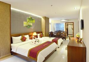 ダナンにあるDo Hai Hotelのベッド2台とテレビが備わるホテルルームです。