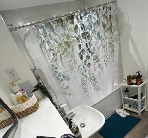 a bathroom with a sink and a shower curtain at Cosy private double room & sofa-bed room in vibrant Hatfield neighbourhood in Hatfield