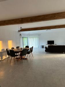 a dining room with a table and chairs and a couch at Cottage Bytheriver in Arpaşu de Sus