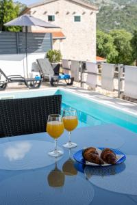 dos copas de vino y pan en una mesa junto a una piscina en Lavanda home en Desne